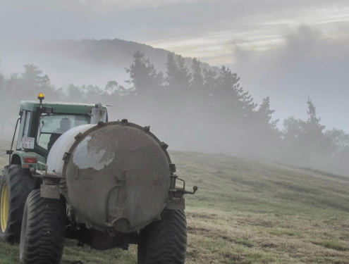 traktor sprer gjødsel på jordet