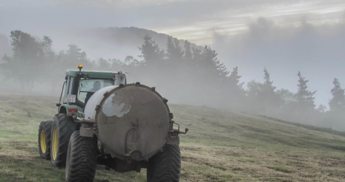 traktor sprer gjødsel på jordet