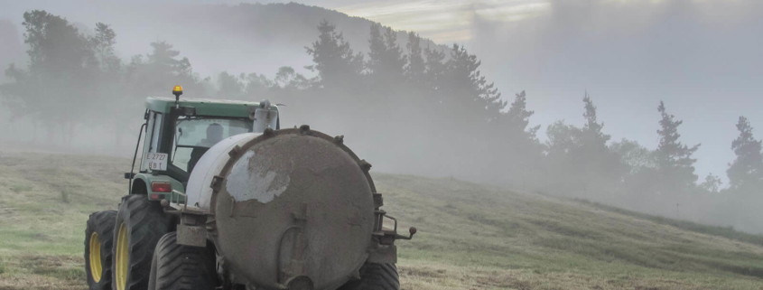 traktor sprer gjødsel på jordet